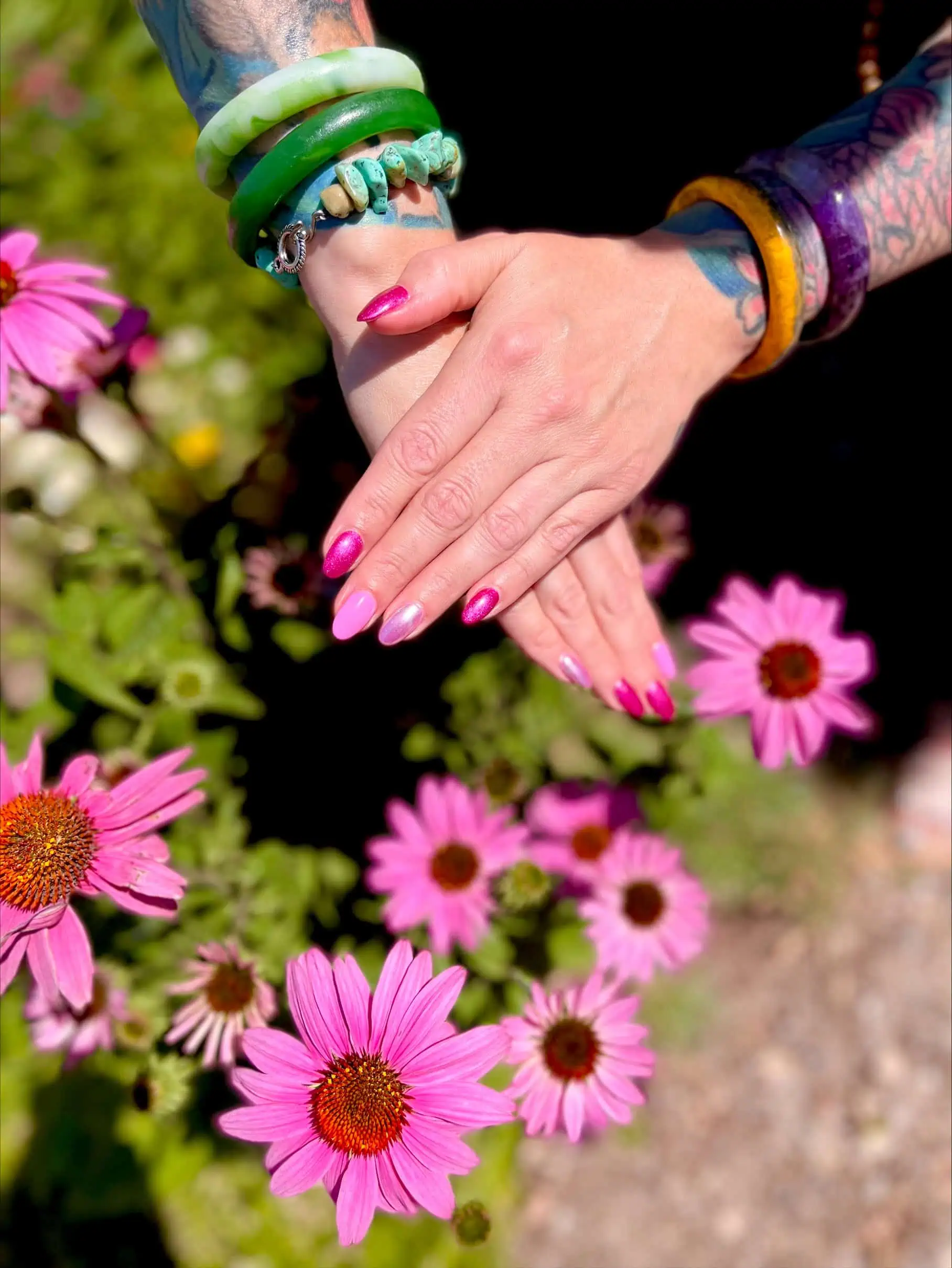 a person's hands with pink nails and bracelets