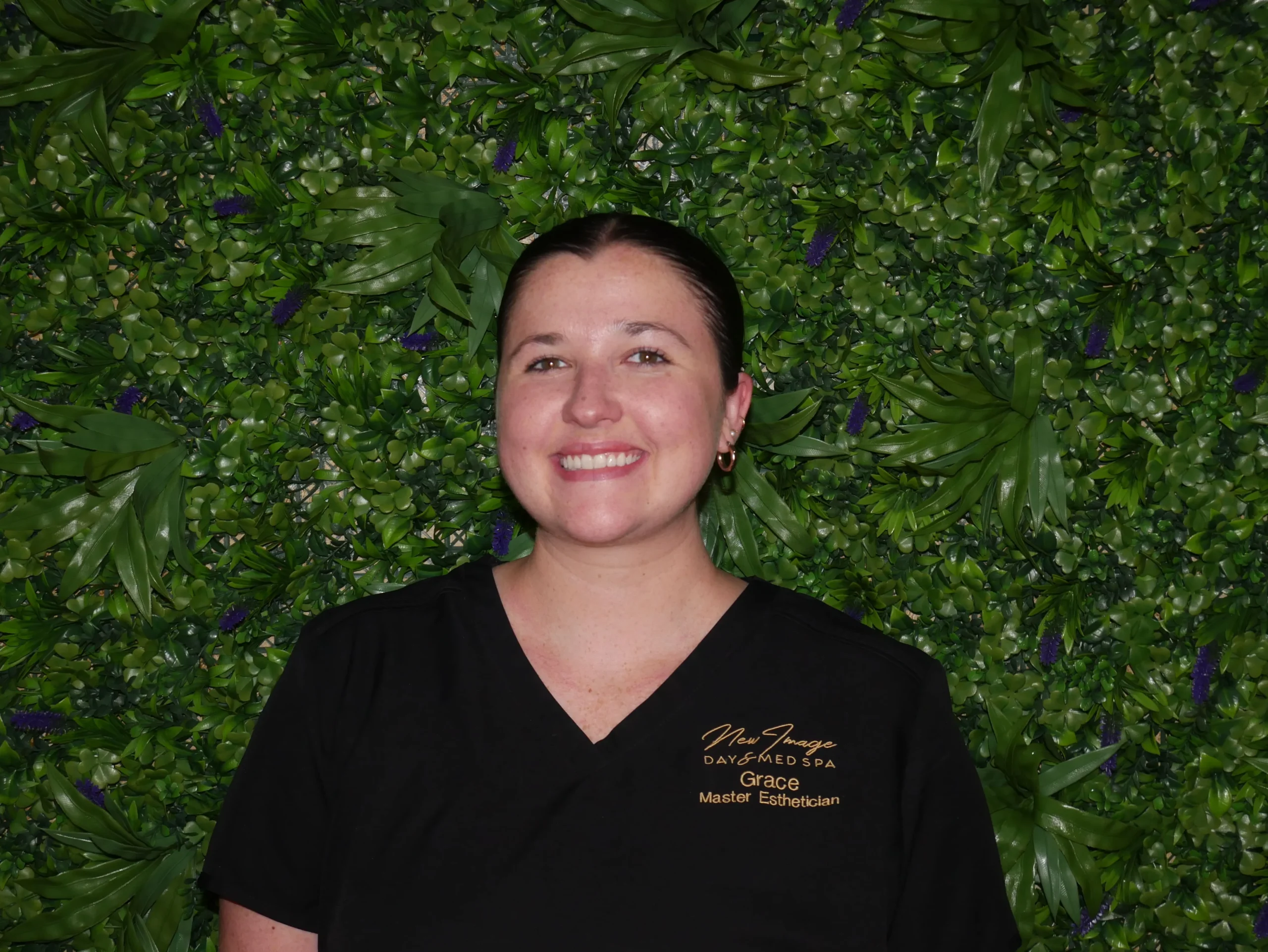 a woman standing in front of a green wall