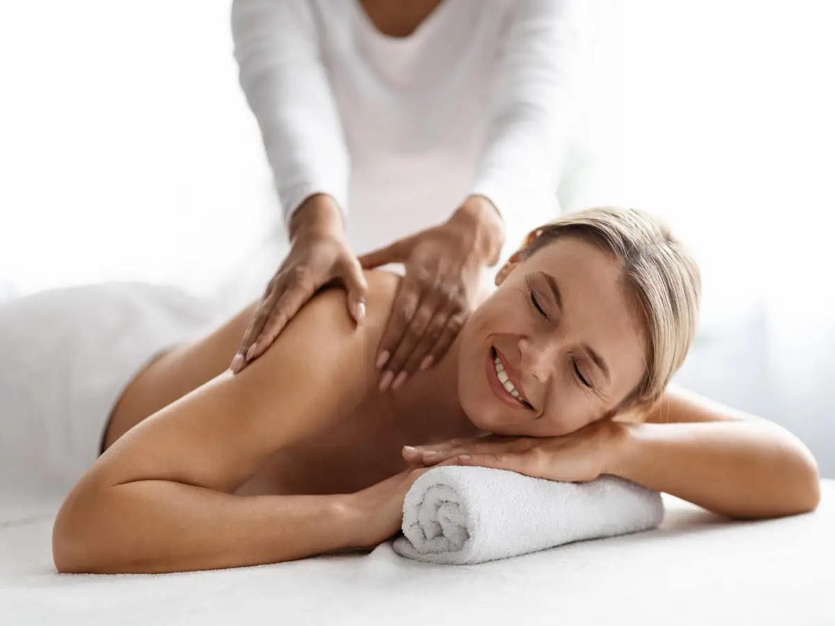 a woman lying on a white towel with her eyes closed