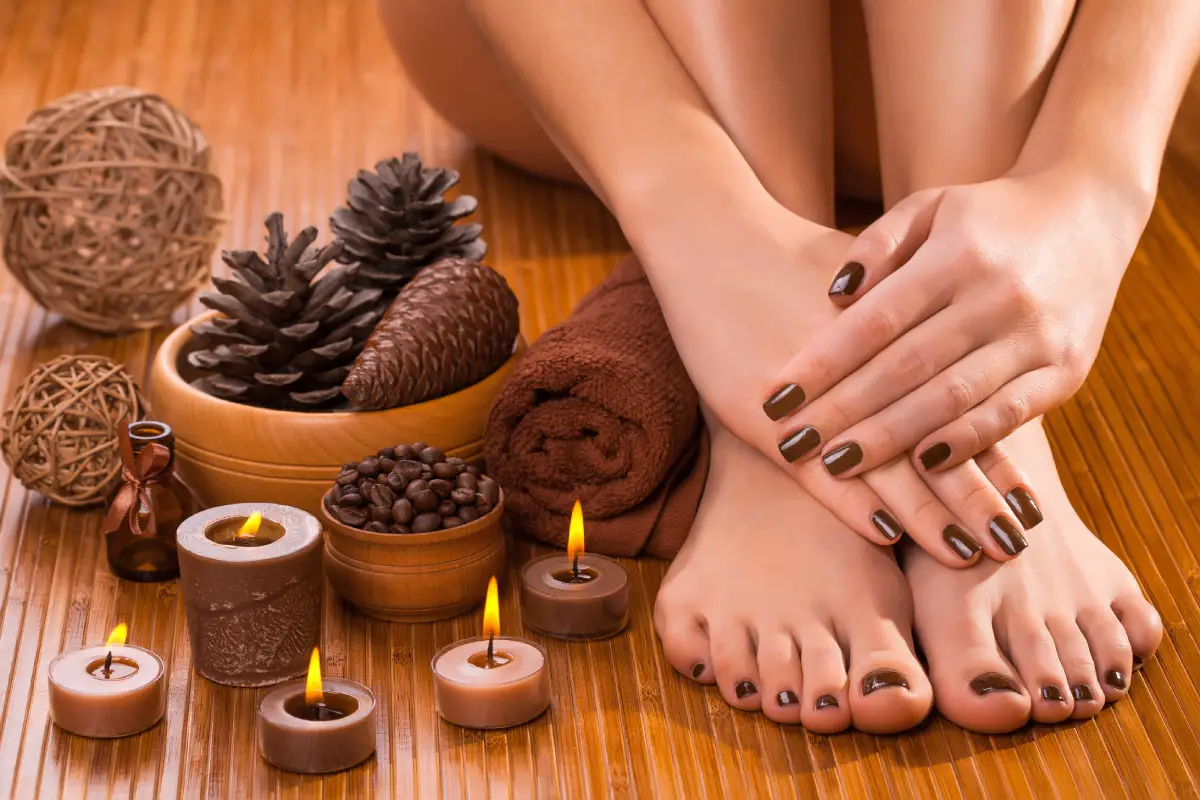 a woman's feet and hands with brown nail polish