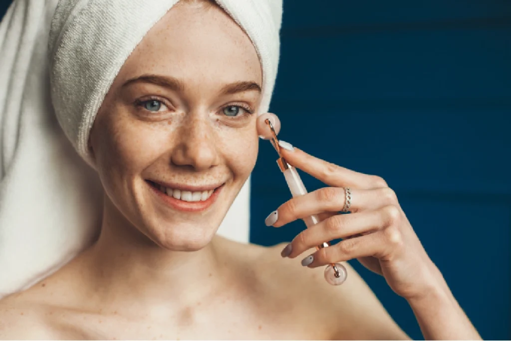 a woman with a towel on her head holding a tool to her face