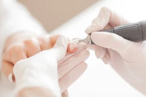 a person using a machine to remove a cuticle