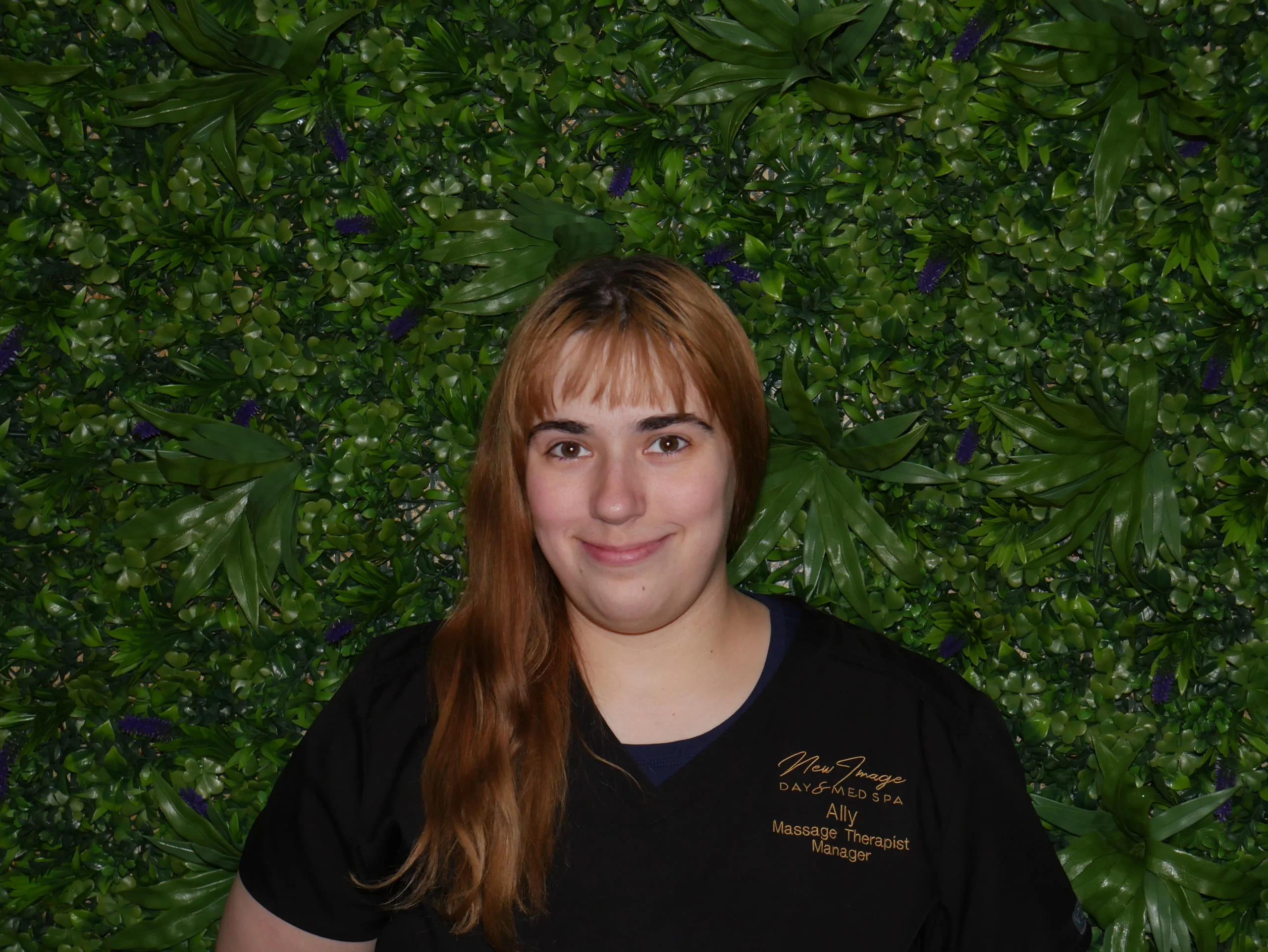 a woman smiling in front of a green wall