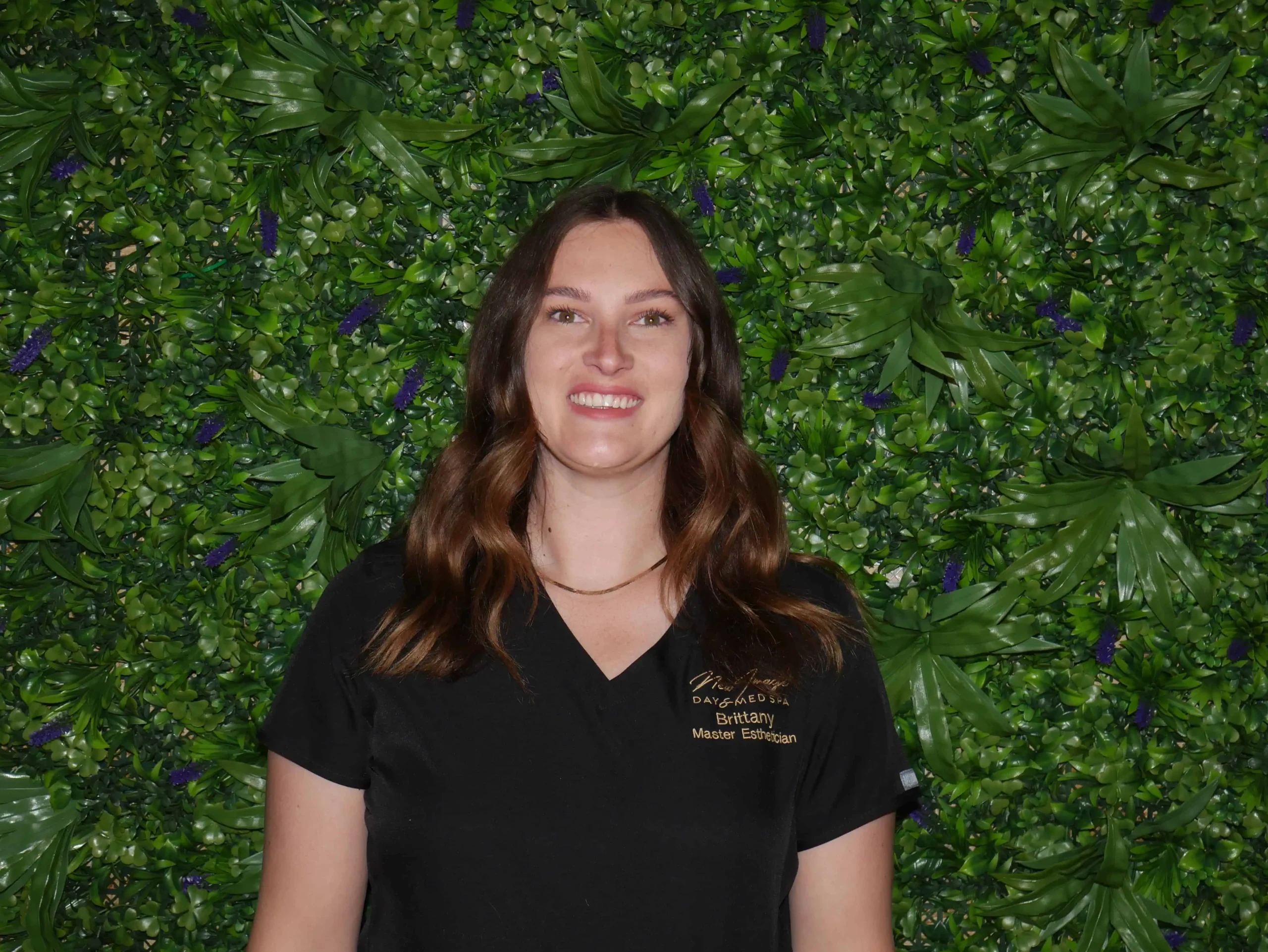 a woman smiling in front of a green wall