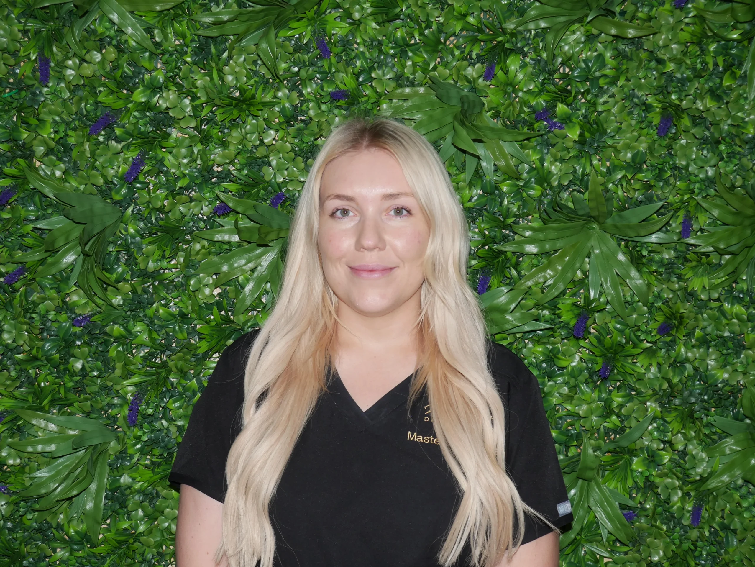 a woman standing in front of a green wall