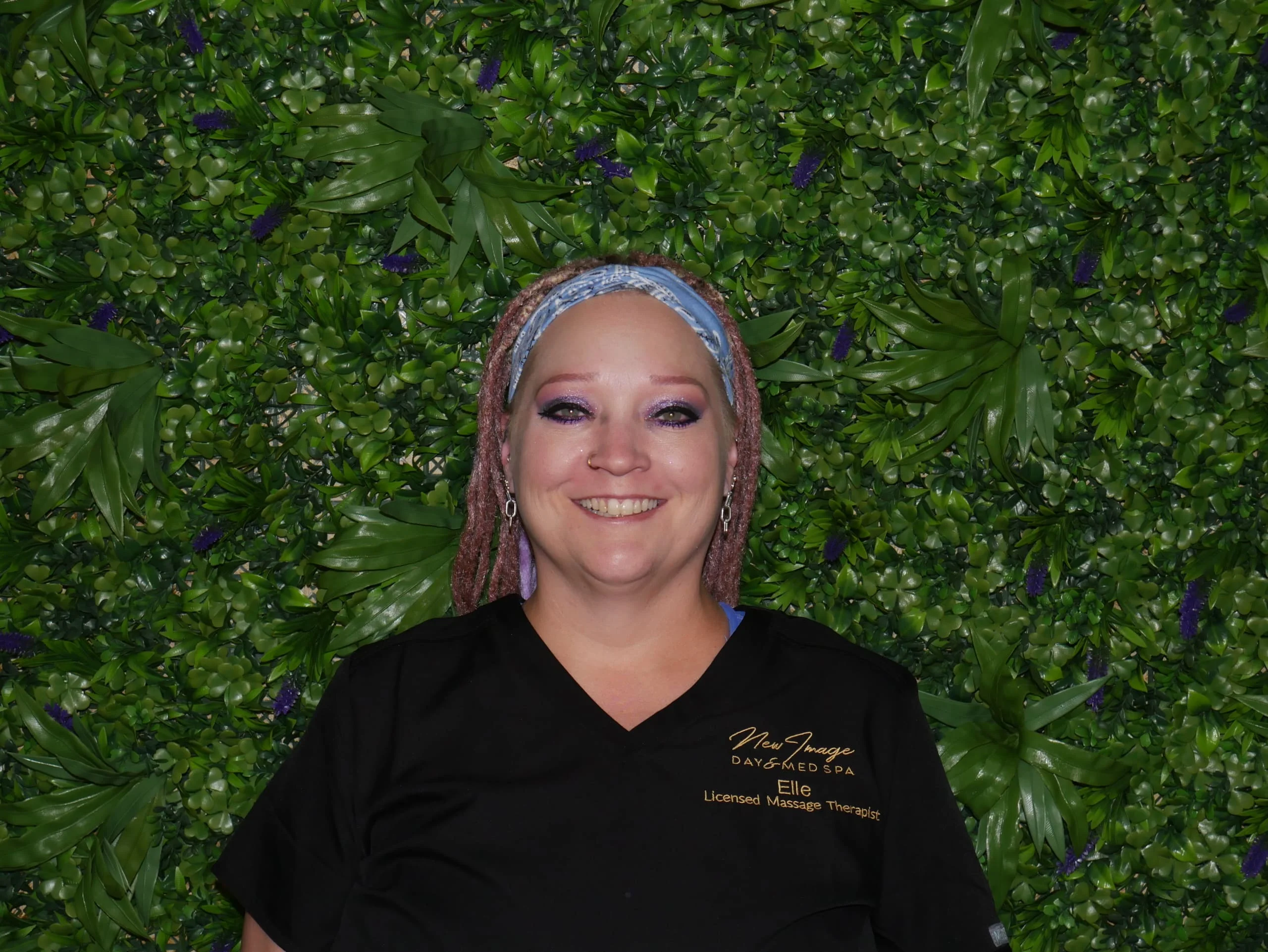 a woman smiling in front of a green wall