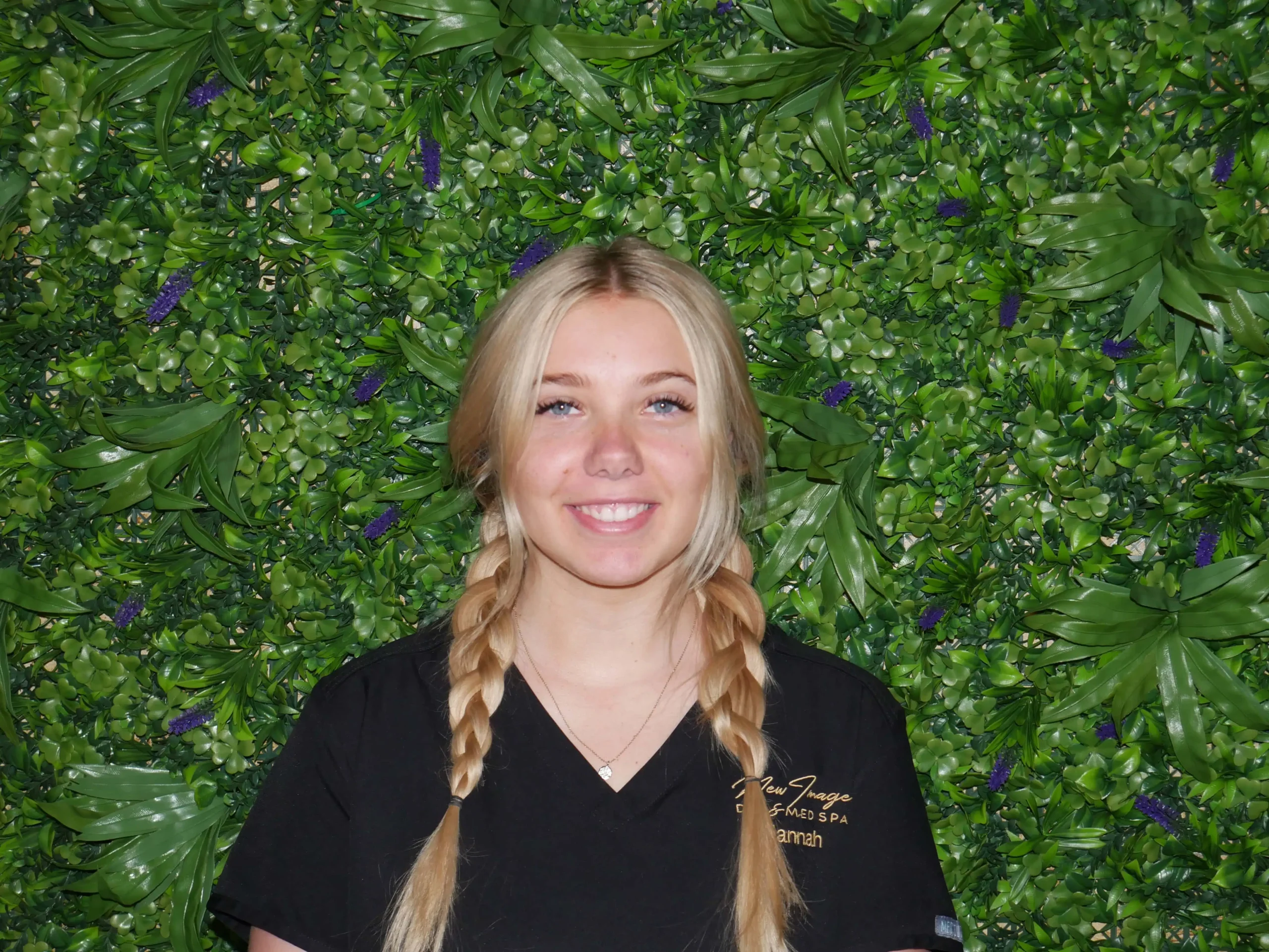 a woman smiling in front of a green wall