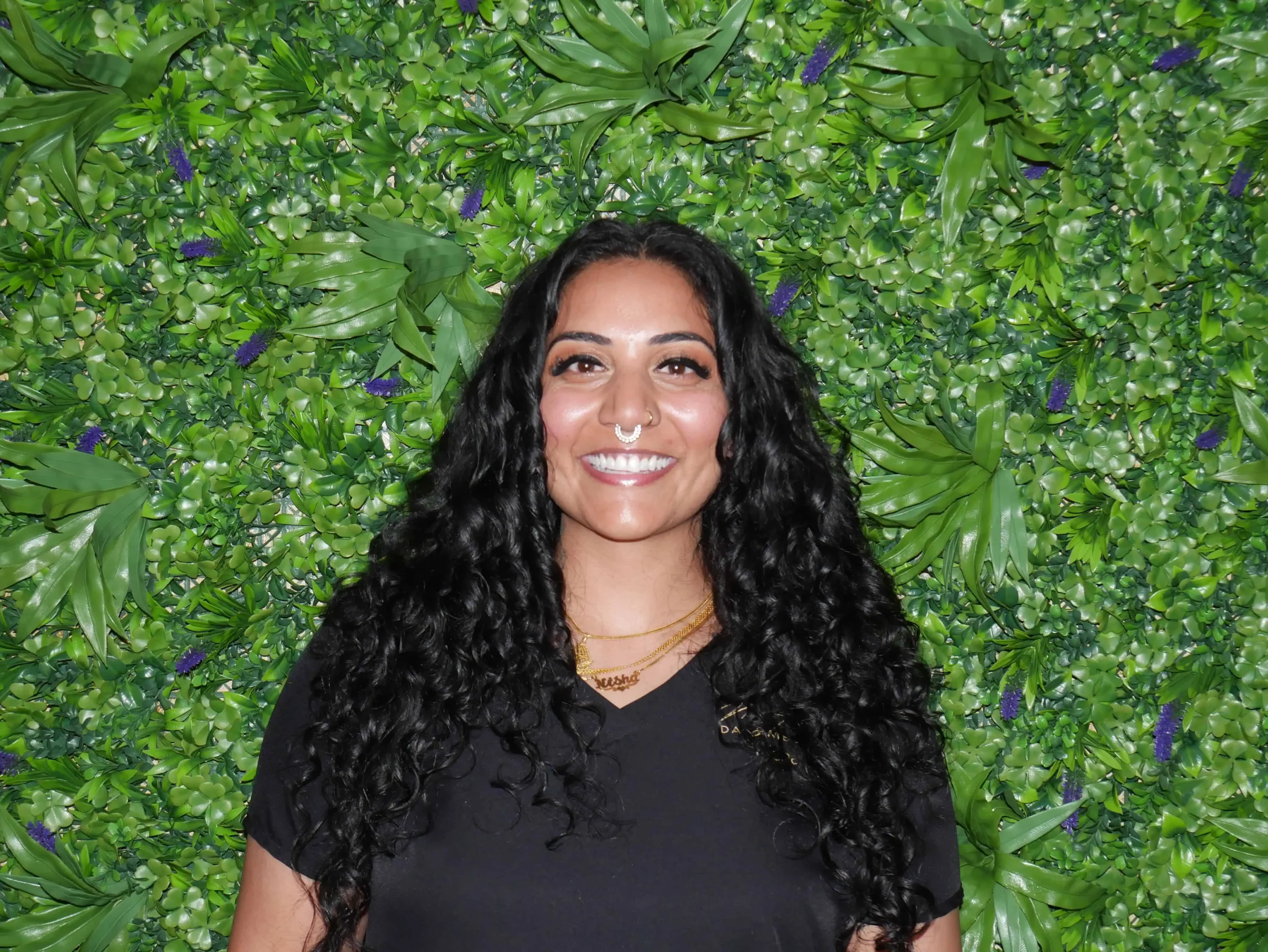 a woman smiling in front of a green wall